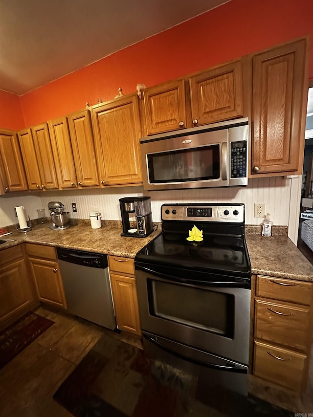 kitchen featuring appliances with stainless steel finishes and brown cabinetry