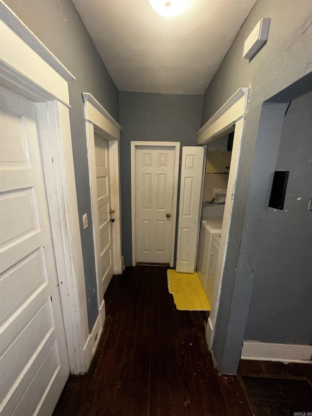 hall with dark wood-style floors and baseboards