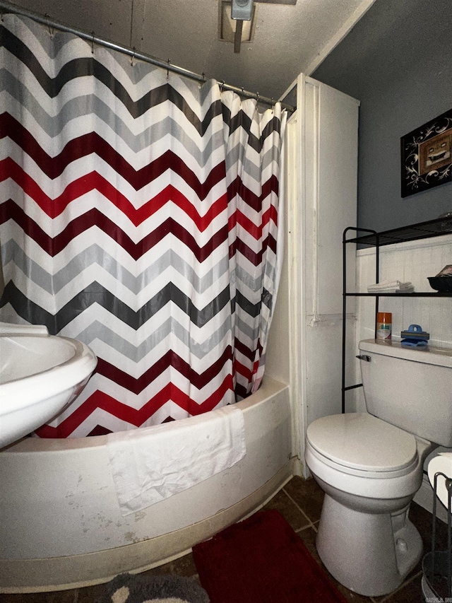 bathroom featuring toilet, shower / tub combo, and tile patterned floors