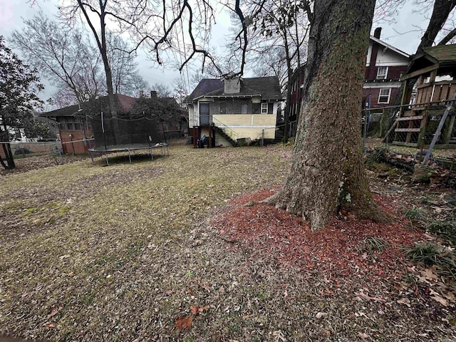 view of yard with a trampoline and fence