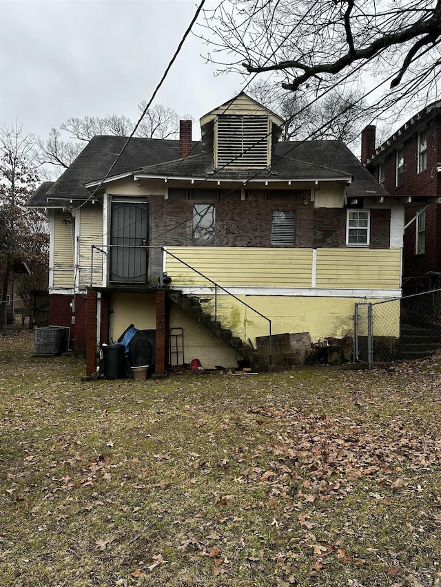 back of property with fence, a chimney, and stairs