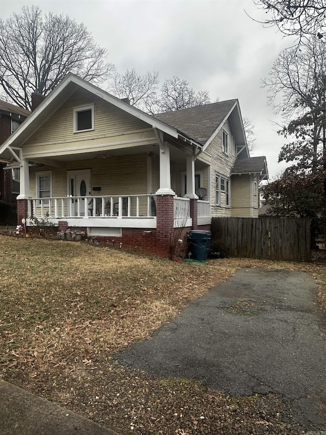 view of front of home with fence and a porch