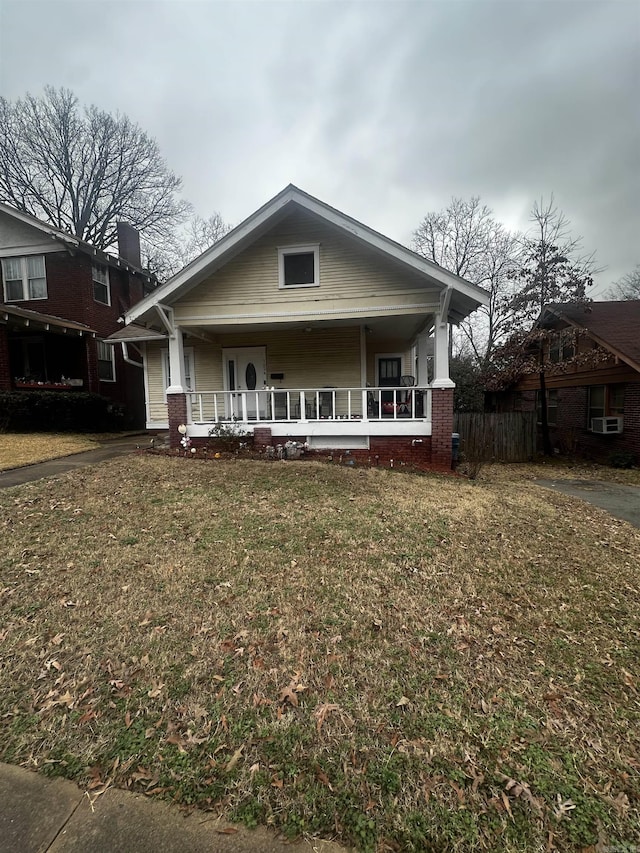 bungalow with a porch, a front yard, and fence