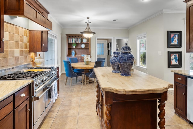 kitchen featuring hanging light fixtures, light stone countertops, light tile patterned floors, ornamental molding, and stainless steel range