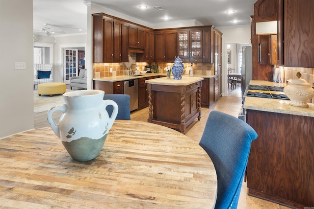 kitchen with ceiling fan, sink, backsplash, dishwasher, and a center island