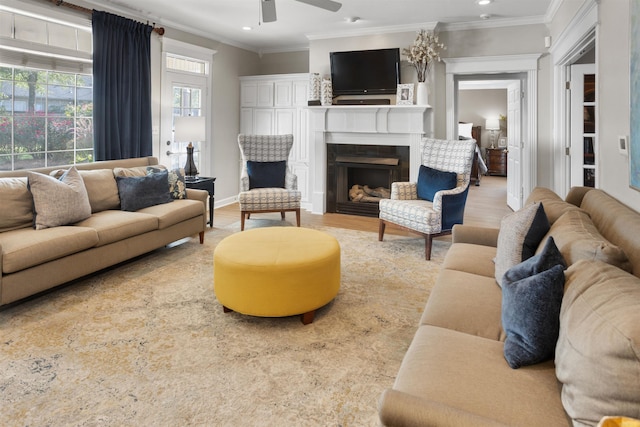 living room featuring crown molding, light hardwood / wood-style floors, and ceiling fan