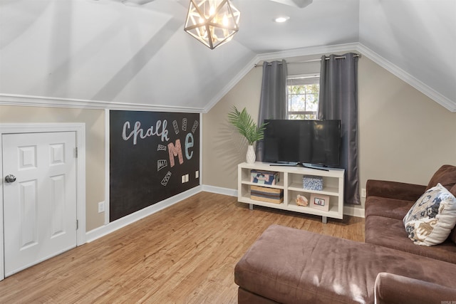 living room featuring an inviting chandelier, crown molding, lofted ceiling, and hardwood / wood-style floors