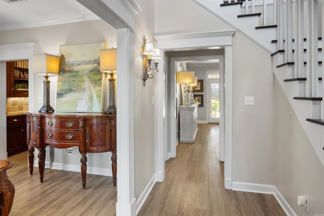 hallway featuring light wood-type flooring and crown molding