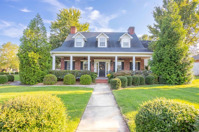 new england style home with covered porch and a front yard