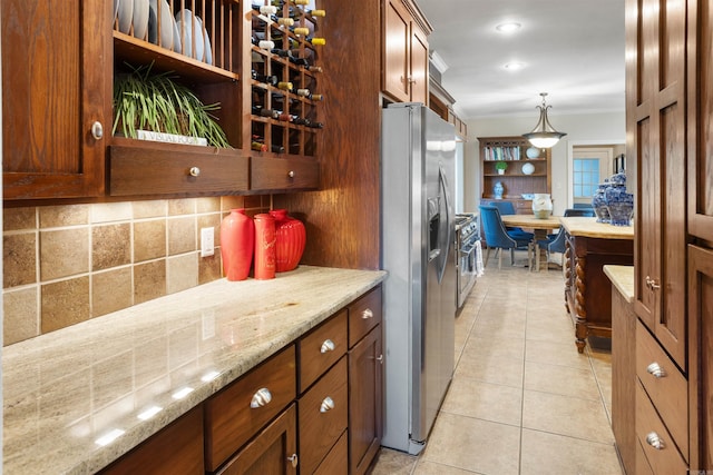 kitchen with light stone countertops, decorative light fixtures, light tile patterned floors, and stainless steel fridge with ice dispenser