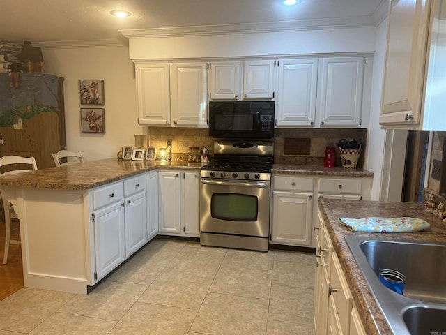 kitchen with white cabinetry, a breakfast bar, backsplash, kitchen peninsula, and gas range