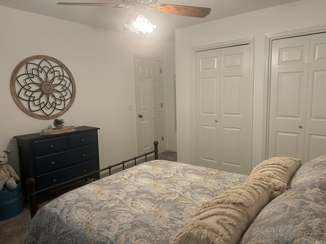 carpeted bedroom with ceiling fan and two closets