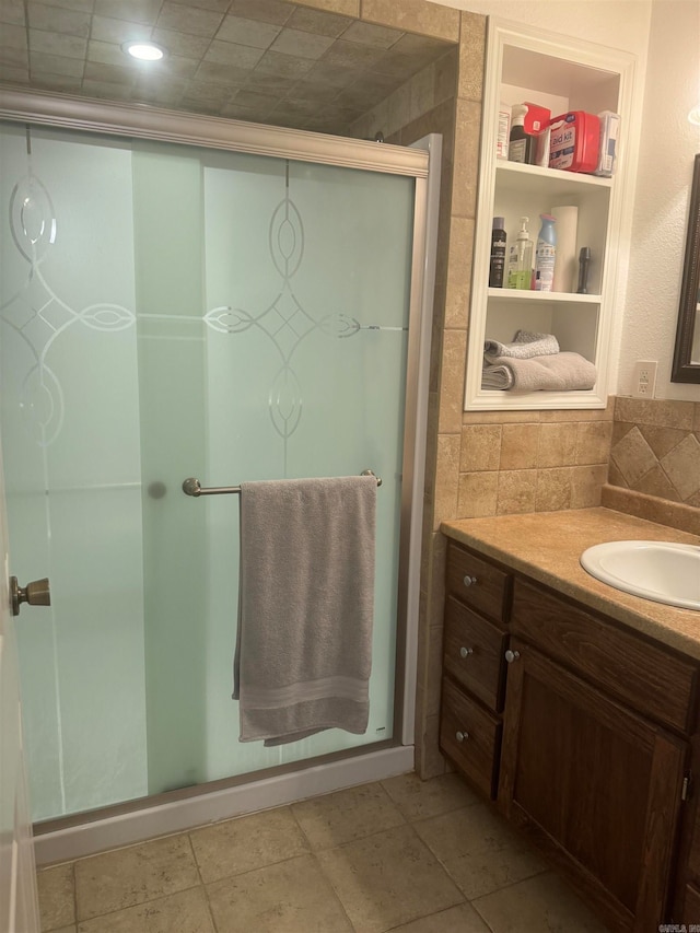 bathroom featuring tile patterned flooring, walk in shower, and vanity