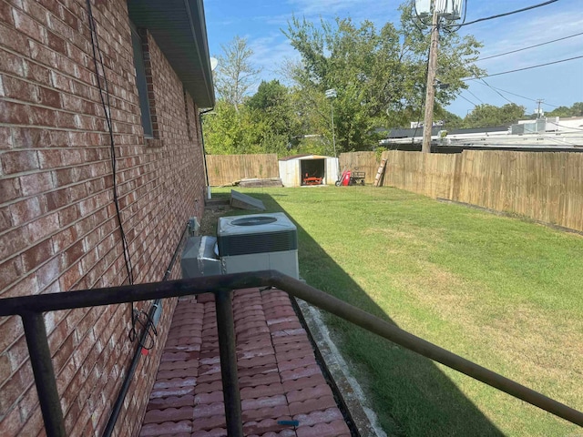 view of yard featuring central AC unit and a shed