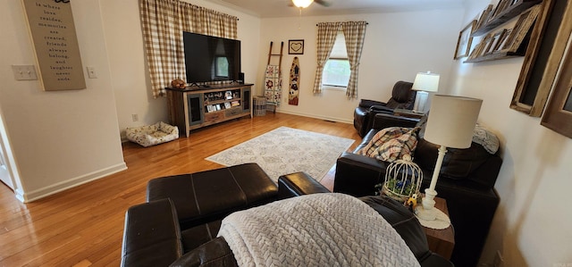 living room with light hardwood / wood-style flooring, ceiling fan, and crown molding