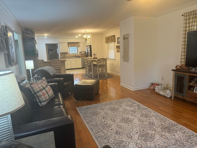 living room featuring an inviting chandelier, hardwood / wood-style flooring, and crown molding