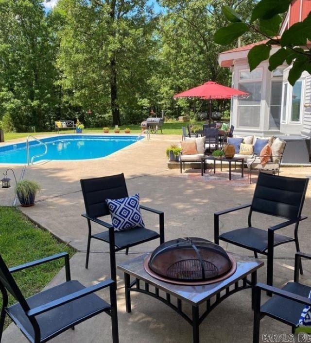 view of pool with an outdoor fire pit and a patio