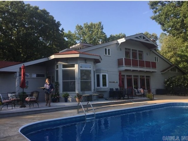 rear view of property featuring a patio and a balcony