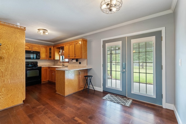 kitchen with black appliances, kitchen peninsula, dark hardwood / wood-style flooring, and plenty of natural light