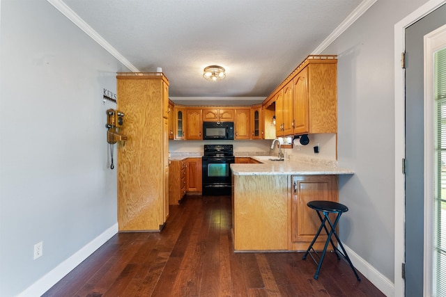 kitchen with black appliances, kitchen peninsula, crown molding, and dark wood-type flooring