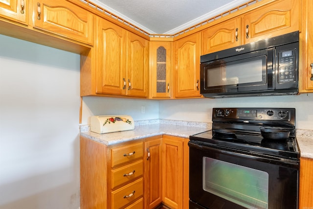 kitchen featuring a textured ceiling, light stone countertops, and black appliances