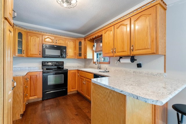 kitchen with sink, kitchen peninsula, crown molding, black appliances, and dark hardwood / wood-style flooring