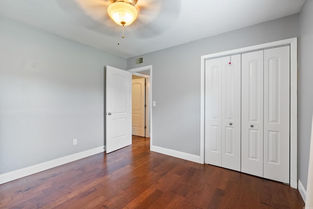 unfurnished bedroom with dark hardwood / wood-style floors, ceiling fan, and a closet