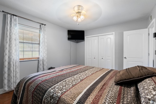 bedroom featuring wood-type flooring, ceiling fan, and a closet