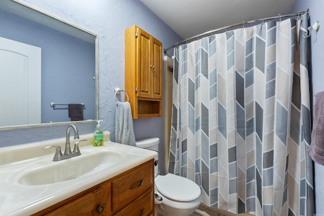 bathroom with walk in shower, vanity, and toilet