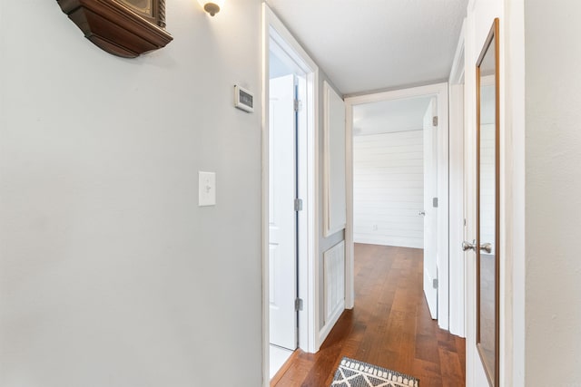 corridor with a textured ceiling and dark hardwood / wood-style flooring