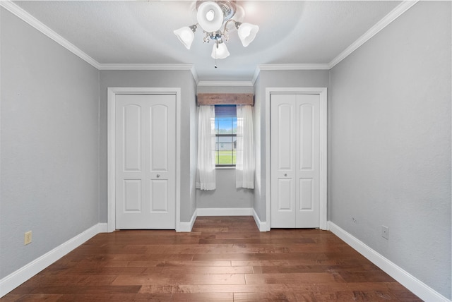 unfurnished bedroom featuring crown molding, dark wood-type flooring, and ceiling fan