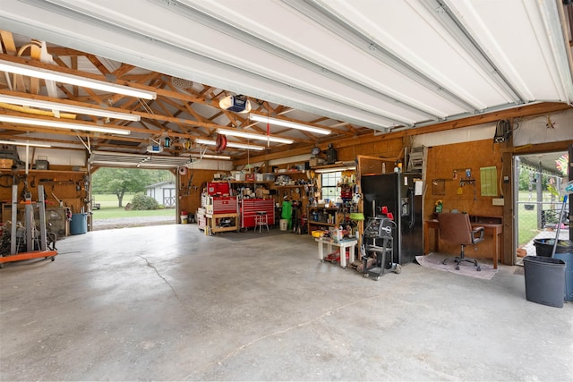 garage featuring a garage door opener, a workshop area, and black fridge