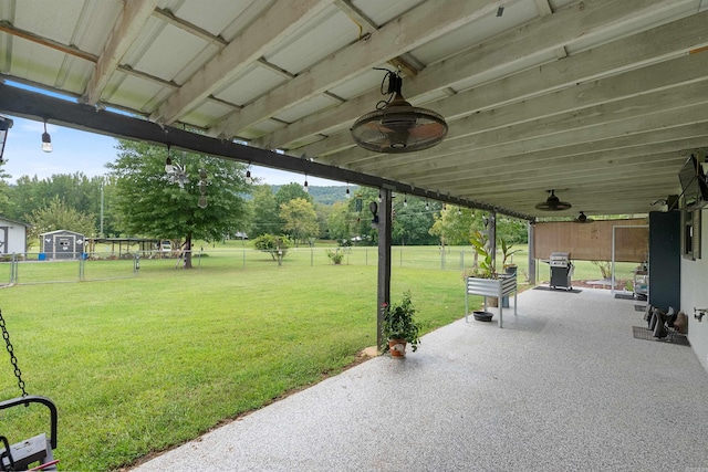 view of patio / terrace with ceiling fan and an outbuilding