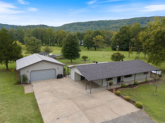 ranch-style home featuring a garage, an outbuilding, and a front lawn