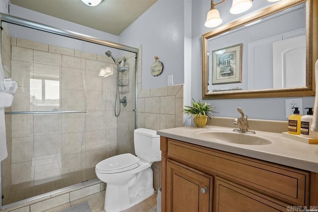 bathroom with vanity, toilet, tile patterned floors, and a shower with shower door