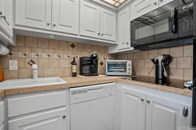 kitchen featuring black appliances, white cabinetry, light countertops, decorative backsplash, and a sink