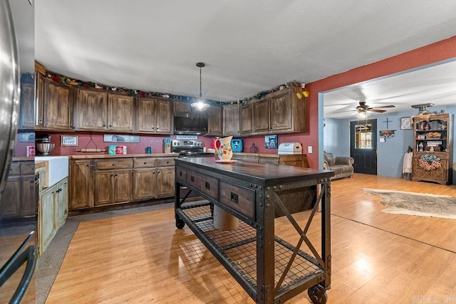 kitchen featuring pendant lighting, ceiling fan, light wood-type flooring, and electric stove