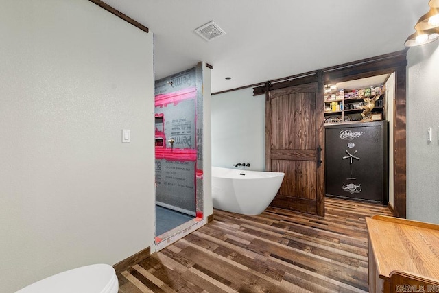 bathroom featuring a tub to relax in, hardwood / wood-style flooring, and crown molding