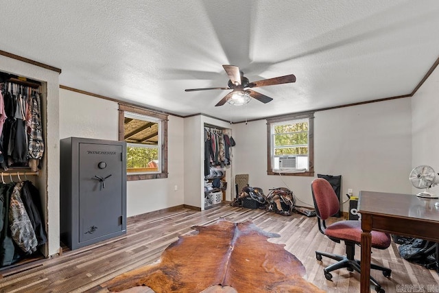 office featuring ceiling fan, cooling unit, wood-type flooring, a textured ceiling, and ornamental molding