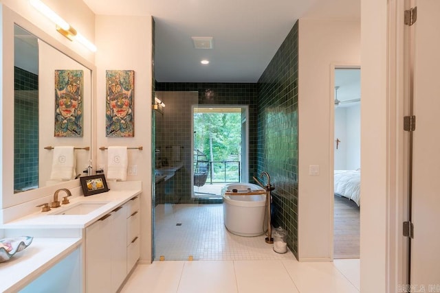 bathroom featuring vanity, plus walk in shower, tile patterned flooring, and tile walls