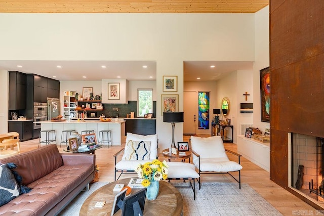 living room with light hardwood / wood-style floors and a high ceiling