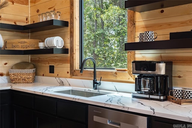 kitchen with dishwasher, light stone countertops, and sink