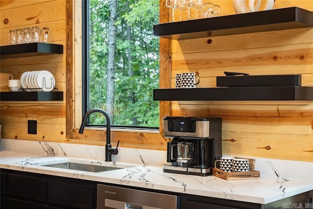 kitchen featuring light stone counters and sink