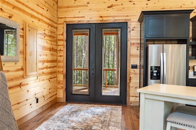 doorway featuring a wealth of natural light, wood walls, french doors, and dark hardwood / wood-style flooring