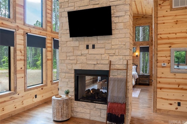 living room featuring a fireplace, light wood-type flooring, and a healthy amount of sunlight