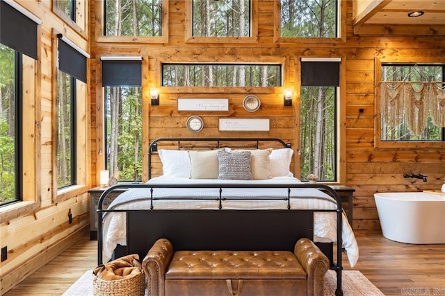 bedroom with a towering ceiling and hardwood / wood-style floors