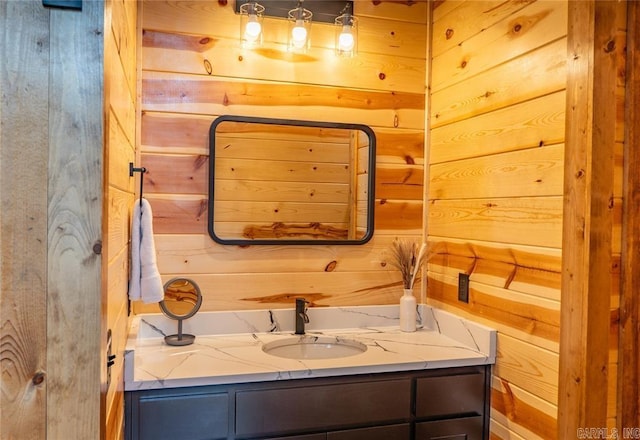 bathroom featuring wood walls and vanity