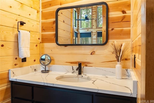 bathroom with wood walls and vanity