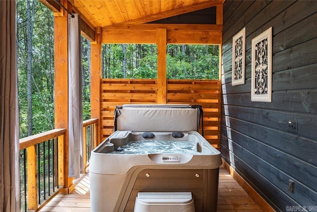 unfurnished sunroom featuring lofted ceiling, wood ceiling, and a hot tub