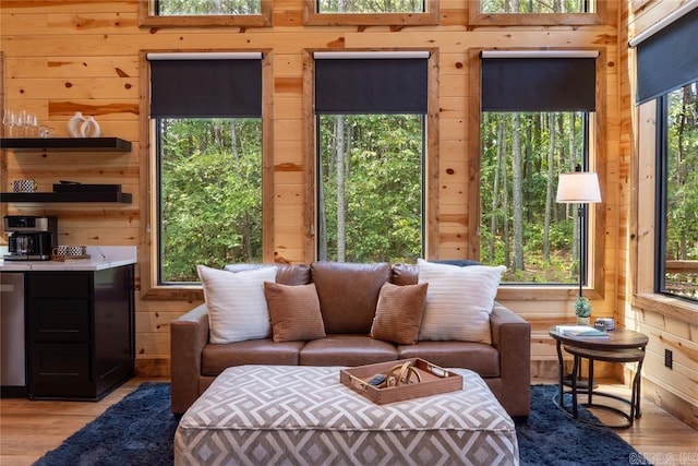 living room with light wood-type flooring and wooden walls